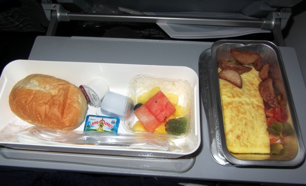 Breakfast: scrambled eggs with fired vegetables and potatoes, bread, butter, fruit salad