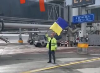 Airport staffer waves with Ukrainian flag to Aeroflot at Tel Aviv airport